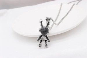 Détail du pendentif lapin mécanique vintage avec pierre noire et zircon sur une chaîne box