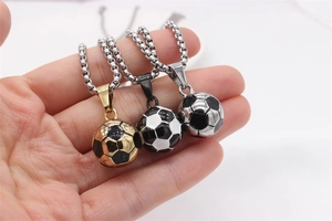Détail de trois pendentifs de football 3D en or et argent sur des chaînes vénitiennes