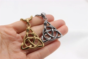 Gros plan détaillé d'un pendentif nœud celtique avec motif serpent à la main
