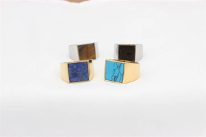 Macro view of men's square gemstone signet rings in gold and silver stainless steel