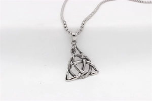 Détail du pendentif vintage en acier argenté avec triquetra celtique et trois serpents