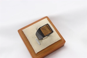 Macro detail of men's black steel ring featuring a square tiger eye stone inlay