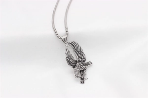 Dettaglio del ciondolo aquila vintage con texture intricata di piume e artigli in acciaio