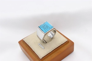 Macro detail of men's square turquoise inlay set in a polished silver steel band