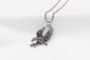Dettaglio ravvicinato di un ciondolo aquila vintage in argento con texture di piume reali