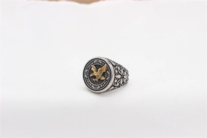 Close-up of retro eagle signet ring with gold eagle relief and engraved floral details