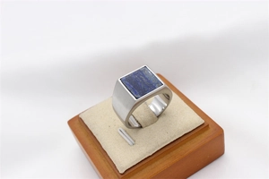 Macro detail of men's square lapis lazuli signet ring with brushed finish steel