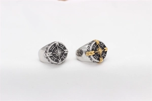 Detail of vintage nautical compass rings in steel and gold with relief carving