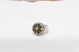 Detailed close-up of a vintage steel compass ring with gold needle and engraved sides