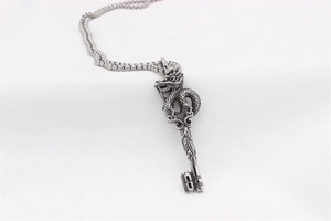 Detailed view of vintage dragon key pendant with intricate scale textures on a steel chain