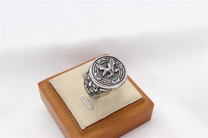 Detail shot of vintage eagle relief and intricate vine patterns on a men's steel ring