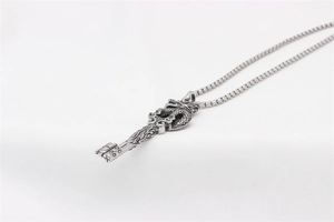 Macro shot of silver dragon key pendant with detailed scales and punk style box chain