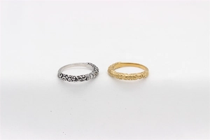 Detailed view of vintage steel rings with intricate floral engravings in gold and silver