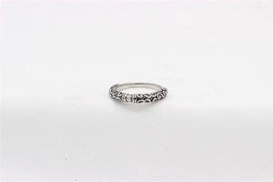 Macro detail of vintage steel ring with intricate scrollwork and rectangle stone