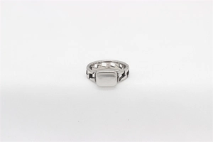 Close-up of silver signet ring with rectangular flat top and industrial chain textures