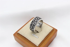 Vue macro d'une bague viking argentée avec motif de nœud celtique gravé en noir