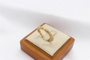 Close-up of vintage gold-plated steel ring with detailed relief textures on display