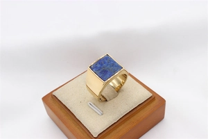 Detailed close-up of a gold titanium ring featuring a square blue lapis lazuli gemstone