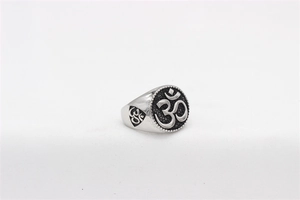 Macro detail of men's stainless steel ring featuring a black Om religious symbol engraving