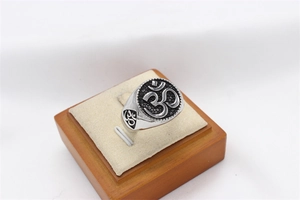Macro detail of men's vintage stainless steel Om ring with embossed religious symbol