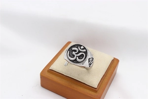 Macro view of vintage stainless steel signet ring with engraved Om symbol and black finish