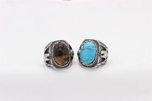 Detail of vintage steel rings with tiger eye and turquoise featuring carved eagle heads