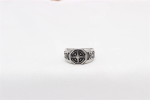 Macro view of vintage stainless steel ring with compass relief and geometric patterns