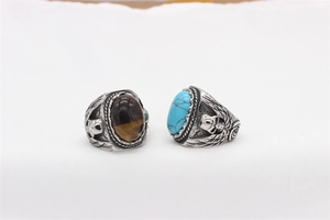 Detail of vintage rings featuring tiger eye stone and turquoise with skull engraving