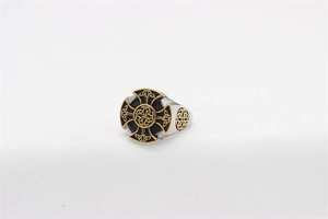 Macro shot of retro Celtic Cross ring with gold knot accents on steel surface