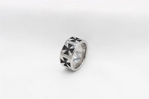 Vue macro d'une bague en titane argenté avec croix de fer en émail noir et bords polis