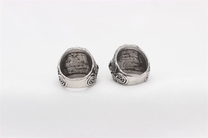 Macro detail of retro skull rings showing embossed floral patterns and distressed metal finish