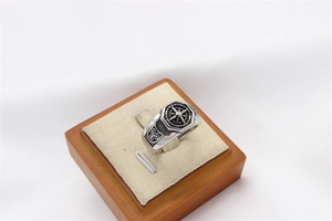Macro detail of men's vintage stainless steel ring with compass pattern on wood stand
