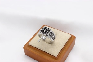 Macro detail of men's vintage steel ring with compass relief and Celtic knot patterns