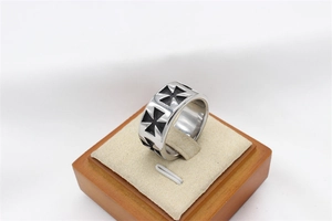 Vue macro d'une bague vintage en acier inoxydable avec des motifs en croix de Malte