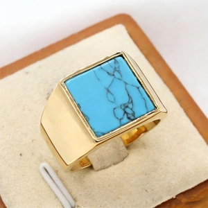 Men's vintage gold square ring with turquoise stone inlay on a beige display stand