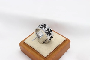 Détail de la bague vintage en acier titane avec motifs de croix de Malte noirs en relief