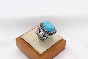 Detailed view of vintage eagle relief and oval turquoise stone on a retro steel ring