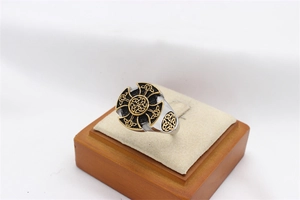 Detailed macro view of retro Viking ring featuring a gold Celtic knot on black shield