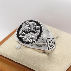 Detail of vintage Viking wolf head signet ring with Celtic knot patterns in steel