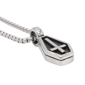 Detail of vintage gothic coffin pendant with embossed cross on silver steel ball chain