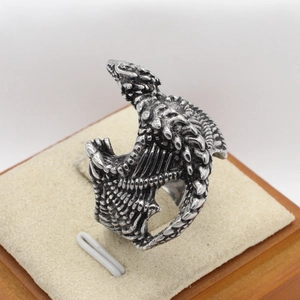 Retro dragon stainless steel open ring with detailed wings and scales on a beige display