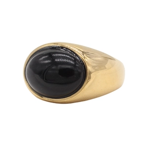 Macro detail of oval black gemstone set in a vintage gold-toned signet ring