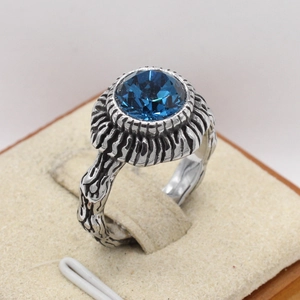 Detail of vintage sun ring showing blue gemstone and antique bark texture finish