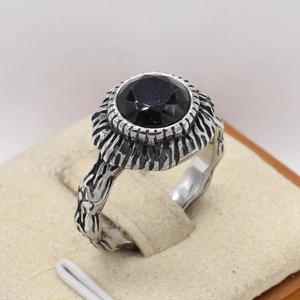 Detailed view of vintage steel ring featuring bark texture and large black gemstone