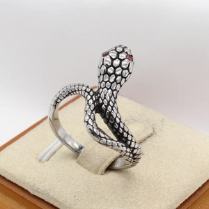 Macro detail of retro snake ring featuring intricate scales and ruby-colored stone eyes