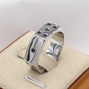 Bague dé pour homme en acier titane argenté poli sur un support de présentation