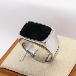 Polished stainless steel men's ring with rectangular black enamel inlay on a pedestal