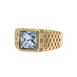 Detalle de anillo cuadrado dorado para hombre con gema azul claro y banda texturizada