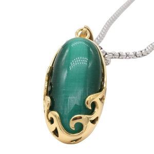 Close-up of green oval cat eye stone pendant with gold hollow wavy base on silver bead chain
