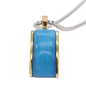 Detail of light blue gemstone pendant with gold frame and silver box chain necklace